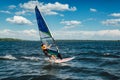 The man athlete rides the windsurf over the waves on lake