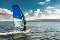 The man athlete rides the windsurf over the waves on lake