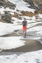 A man athlete runs on a road through an alpine pass Royalty Free Stock Photo