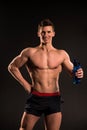 Man athlete with sport bottle on dark background Royalty Free Stock Photo