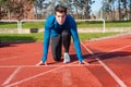 Man athlete on the starting line of a running track at the stadium. Royalty Free Stock Photo