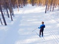 Man athlete trains cross-country skiing in winter on snow covered track in forest Royalty Free Stock Photo