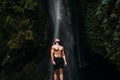 A man of athletic build at the waterfall. A man travels the world. Man at the waterfall. Travel to Bali Indonesia. Lone traveler.