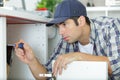 man attaching pipe under sink Royalty Free Stock Photo