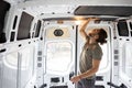 Man attaching thermal insulation in a camper van