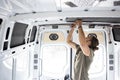 Man attaching thermal insulation in a camper van