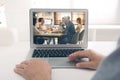 Man attending online video conference via laptop at table Royalty Free Stock Photo