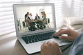 Man attending online video conference via laptop at table, closeup Royalty Free Stock Photo