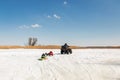 Man on ATV quadbike riding sledges with kids in tow on frozen lake surface at winter. Winter extreme sports and Royalty Free Stock Photo