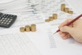 Man is auditing account by pencil with step gold coins