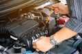 Man or auto mechanic worker hands checking the car engine oil and maintenance.