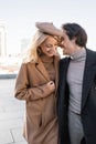 man in autumn coat laughing near stylish women in beret outdoors,stock image Royalty Free Stock Photo