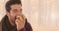 Man in Autumn eating apple in bright forest Royalty Free Stock Photo