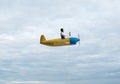 Man in aviator hat driving propeller plane