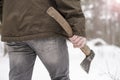 Man with an ax in his hand go in winter snow-covered forest, frosty day Royalty Free Stock Photo