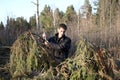 Man with an axe looks at the tumbled down wood