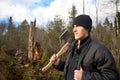 Man with an axe looks at the tumbled down wood Royalty Free Stock Photo