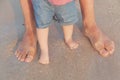 Man and baby feet standing in shallow water waiting for the wave. Bare feet father and his little daughter or son Royalty Free Stock Photo