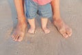 Man and baby feet standing in shallow water waiting for the wave. Bare feet father and his little daughter or son Royalty Free Stock Photo