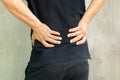 Man with back pain isolated on grey background.