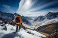 A man, backpack on, admires the vastness of a mountain landscape