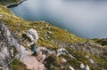 Man with backpack climbing up holding chains to mountain summit Royalty Free Stock Photo