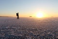 The man with a backpack going on ice on the river at sunset Royalty Free Stock Photo