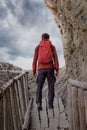 Man with a backpack during a hike on an old wooden bridge Royalty Free Stock Photo