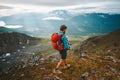 Man with backpack hiking with baby travel outdoor in Norway mountains