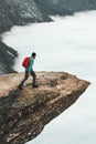 Man with backpack hiking on Trolltunga rocky cliff Royalty Free Stock Photo