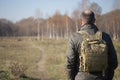 Man with a backpack on his shoulders walking on path in park Royalty Free Stock Photo