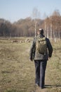 Man with a backpack on his shoulders walking on path in park Royalty Free Stock Photo