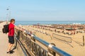 Man with backpack looks at the sea from the beach bridge Royalty Free Stock Photo