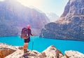 Man with backpack near lake Big Alo on rocky mountain background. Fann Mountains