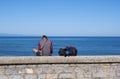 Man with backpack next to the beach and the blue sea, city of San Sebastian