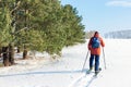 Man with backpack on skis on snow on sunny winter day.