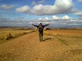 Man with backpack spreading arms and walking in field. Camino de Santiago concept. Pilgrimage concept. Royalty Free Stock Photo