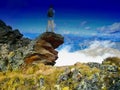 Man with backpack standing on a cliff enjoying a view to valley in scenic mountain landscape Royalty Free Stock Photo