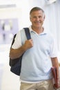 A man with a backpack standing in a corridor