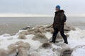 Man with a backpack standing in the evening on the ice near a freezing river, Ob reservoir, Novosibirsk city, Russia