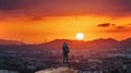 A man with backpack standing on the mountain enjoying beautiful sunset view in Osaka city, Japan. Travelling and adventuring in As