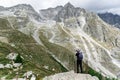 Man with a backpack standing on an observation deck and photographing a mountain range, Mont Blanc Royalty Free Stock Photo