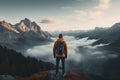 Man with backpack standing on the top of the mountain and looking at the valley, rear view of Sporty man on the mountain peak Royalty Free Stock Photo