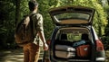 Man with backpack stands near a car with trunk open