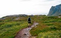 A man with a backpack stands on top of a mountain