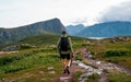 A man with a backpack stands on top of a mountain