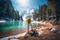 Man with backpack on the stone near lake with azure water