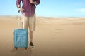 Man with backpack and suitcase traveling to the desert