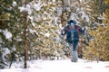 Man with backpack trekking in mountains. Cold weather, snow on