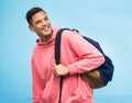 Man, backpack and university student happy in studio, laughing and smile on blue background. Young, handsome and college Royalty Free Stock Photo